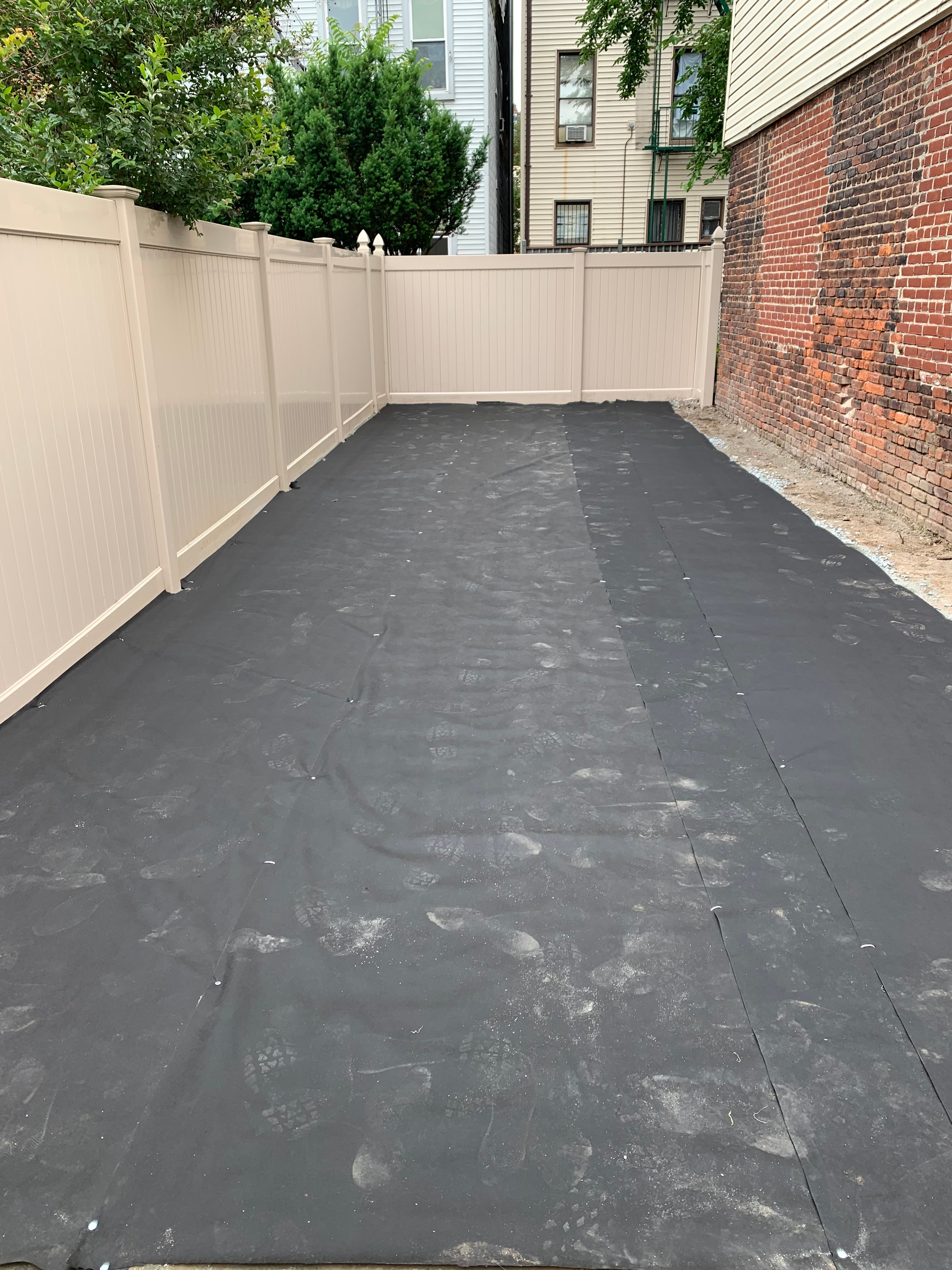 Weed barrier fabric installed over prepared base prior to artificial turf laying