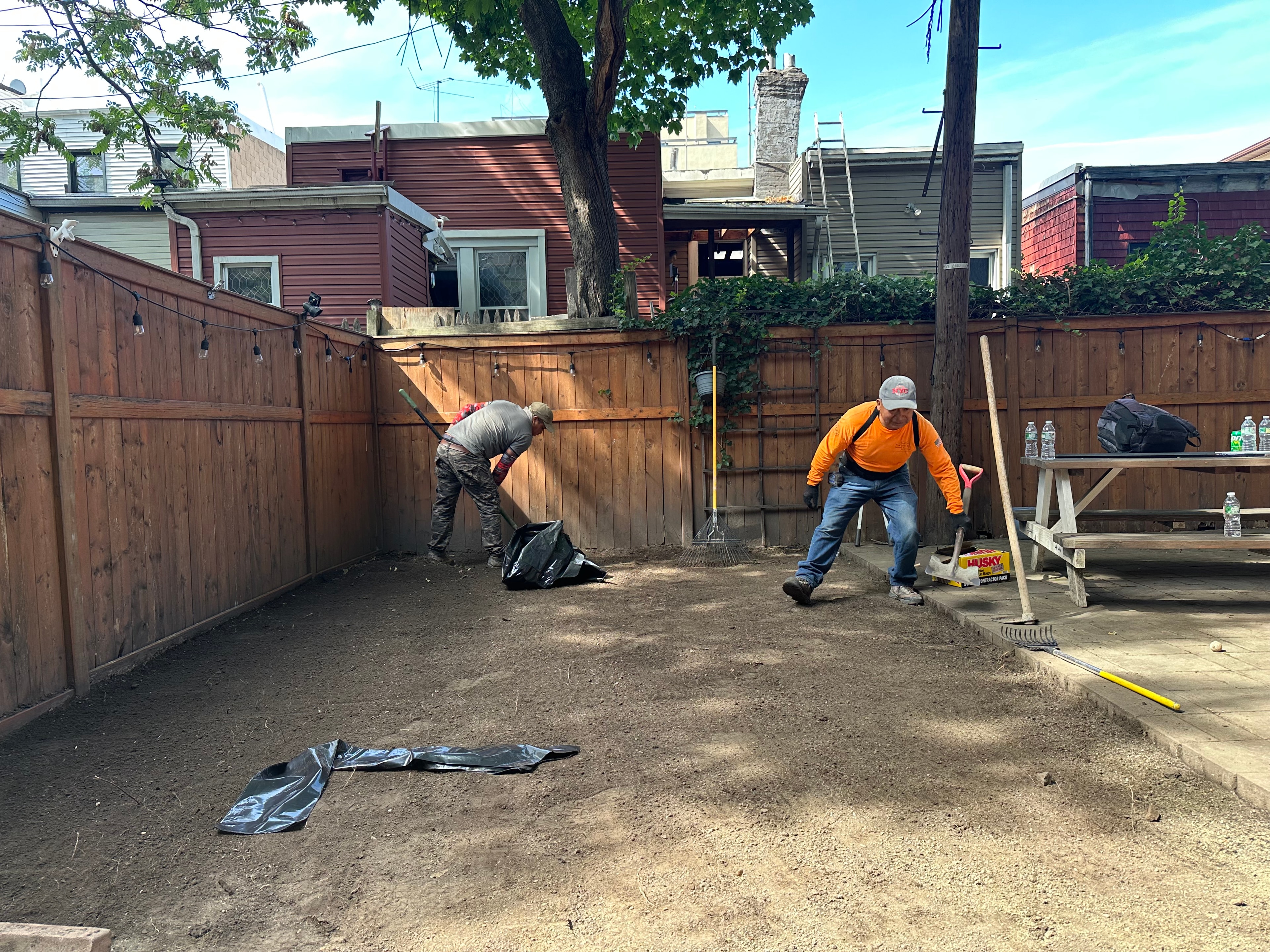 JKPOH crew grading and raking bare soil during base preparation for artificial turf