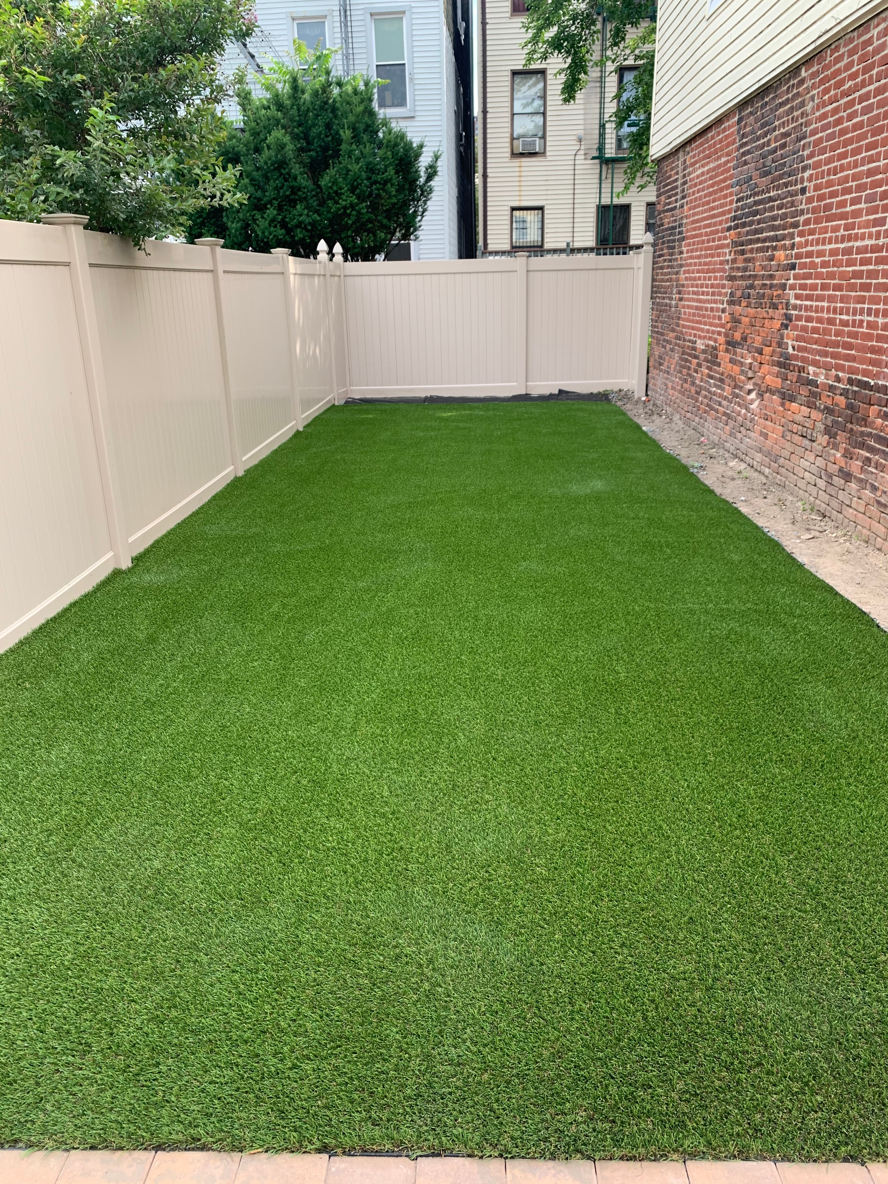 Overhead view of completed artificial turf installation alongside concrete pathway