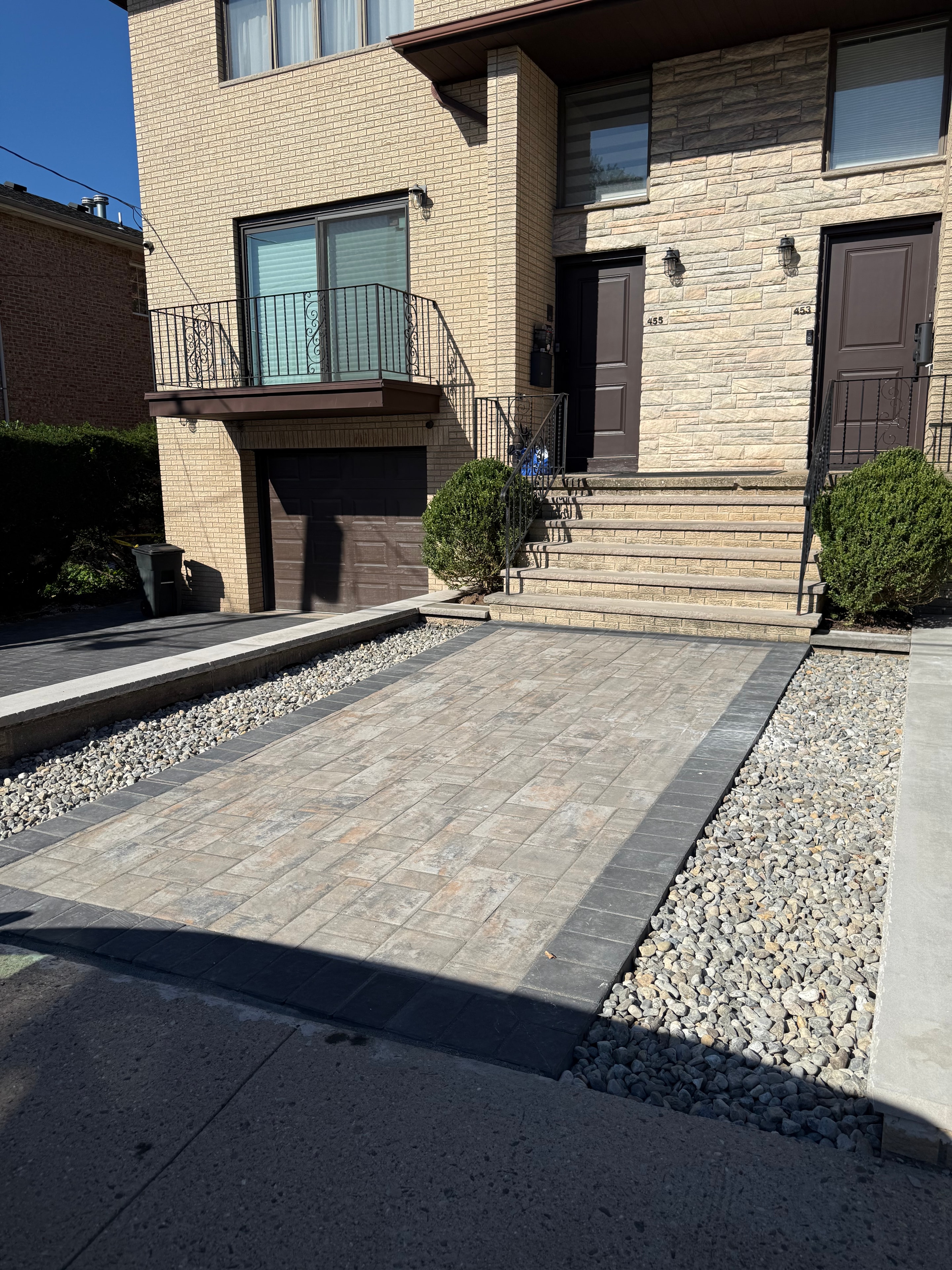Overhead view of completed paver driveway, retaining wall, gravel drainage strip, and lawn restoration in Fort Lee, NJ