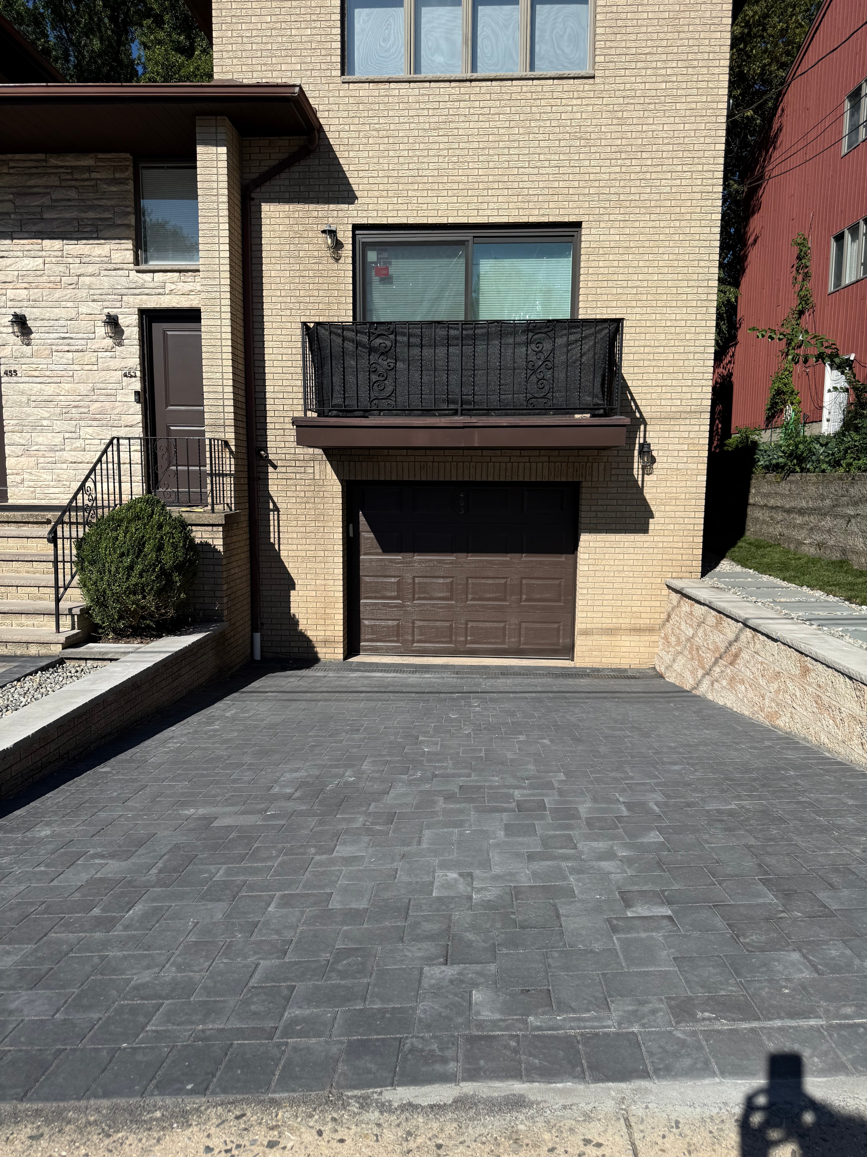 Retaining wall with decorative stone cap and gravel drainage strip alongside a residential driveway — Fort Lee, NJ