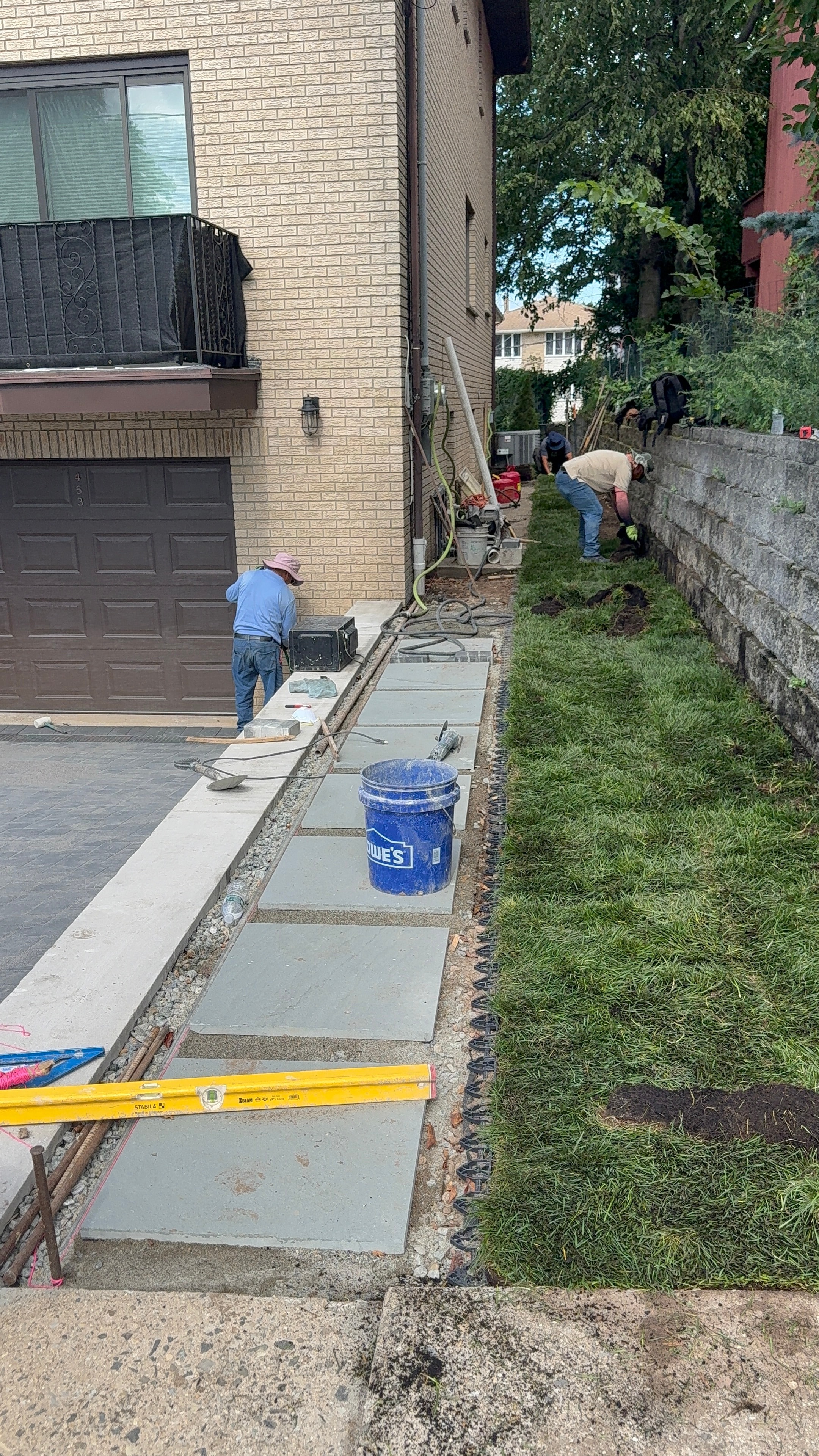 JKPOH crew installing stepping-stone walkway alongside driveway with sod being laid — Fort Lee, NJ